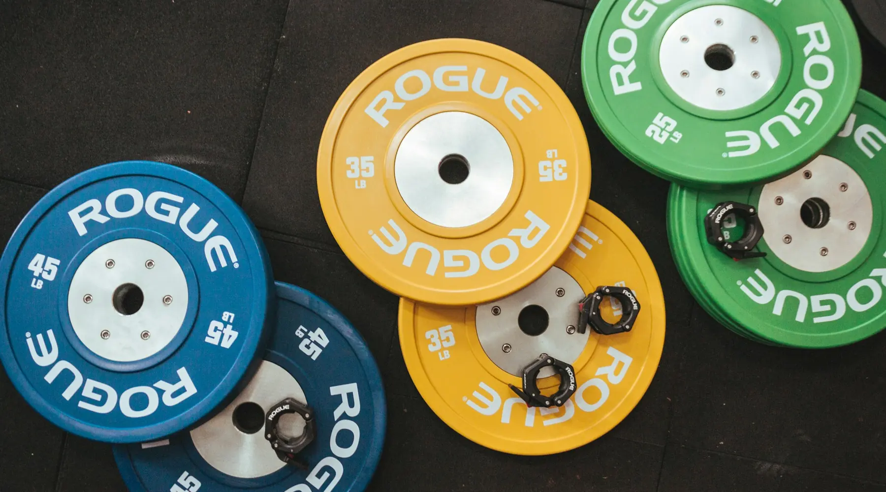 Colored bumper plates laid out on a gym floor