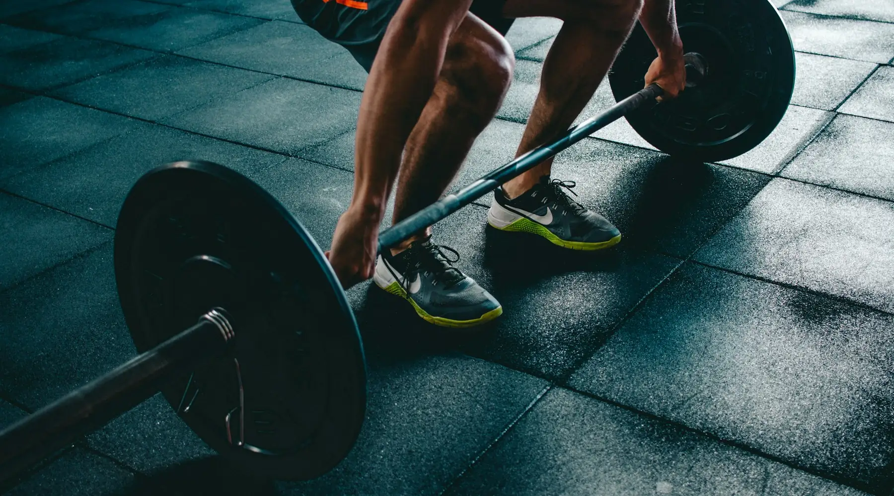 A lifter gripping a loaded barbell before a deadlift, seen from above